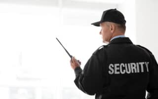 Security patrol officer inspecting a Fort Worth small business parking lot at night to prevent after-hours theft and vandalism.